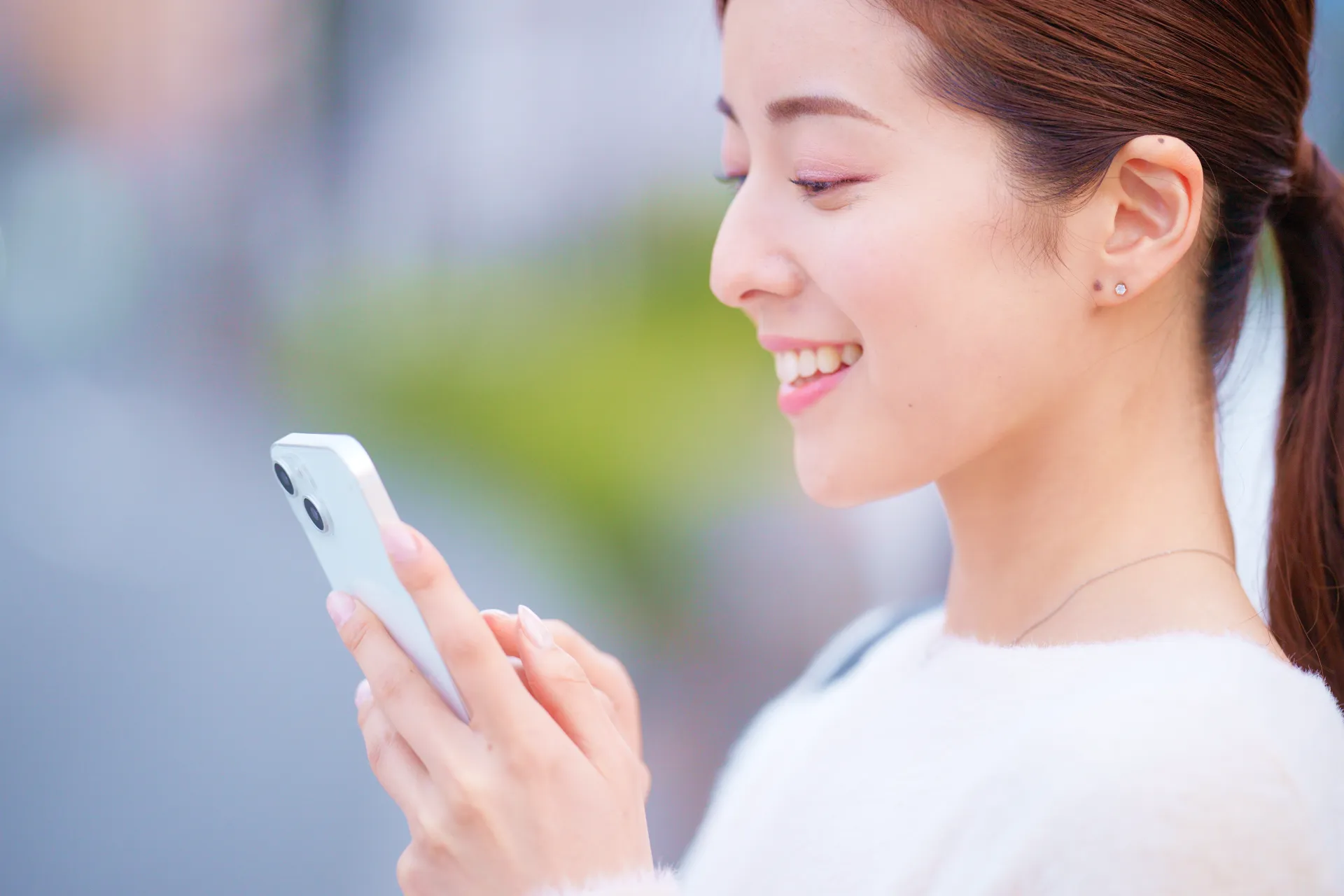 スマホを見て微笑む女性
