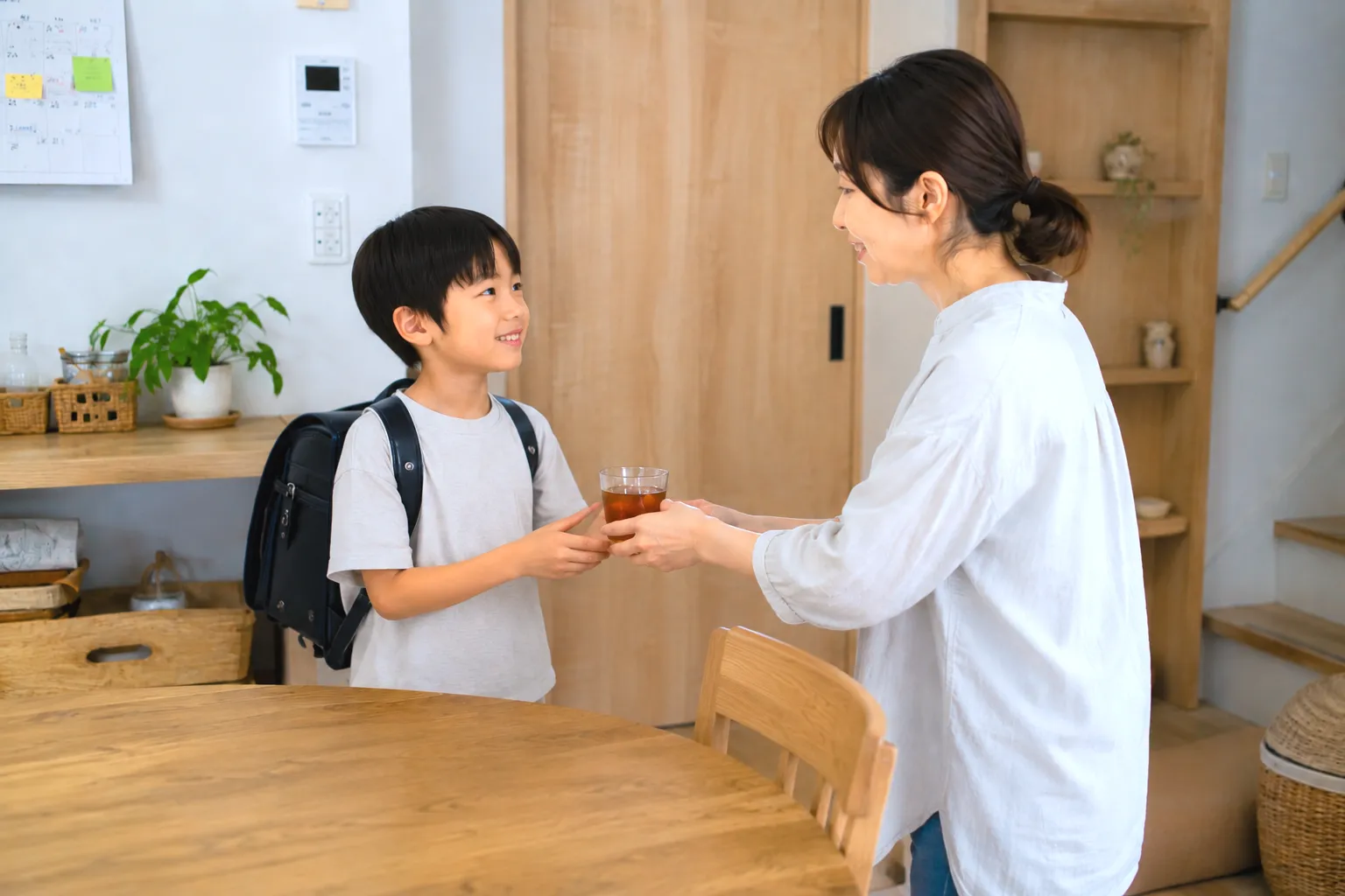 子どもにお茶を差し出す母