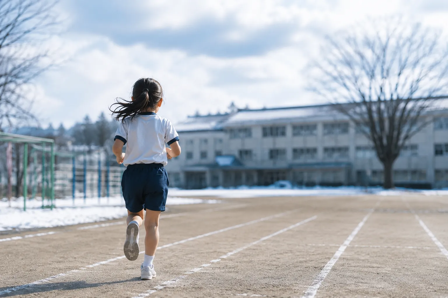 冬の校庭を走る少女